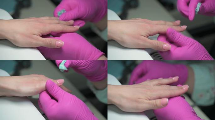 修指甲美容师的特写镜头用纸巾擦拭客户的抛光指甲