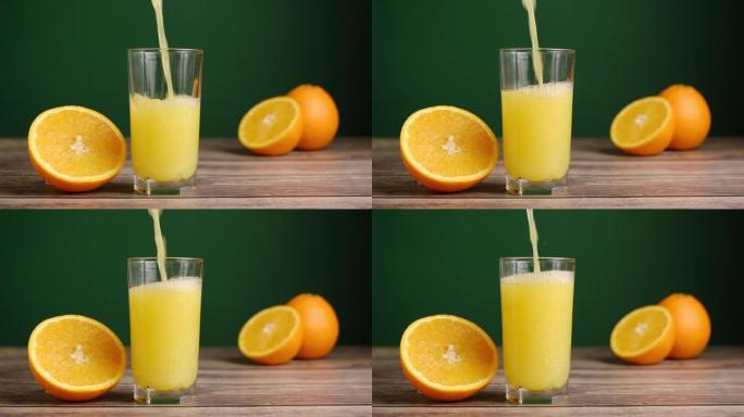 将新鲜的黄色果汁倒入木制桌子上的高玻璃杯中，绿色背景为橘子。自制水果橙汁、苏打水或柠檬水。有机维生素