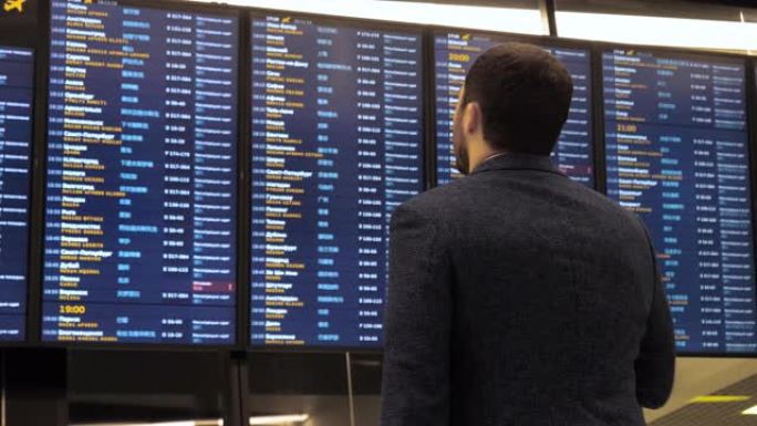 乘客在机场看时刻表屏幕，国际航班，商务人士出国旅行