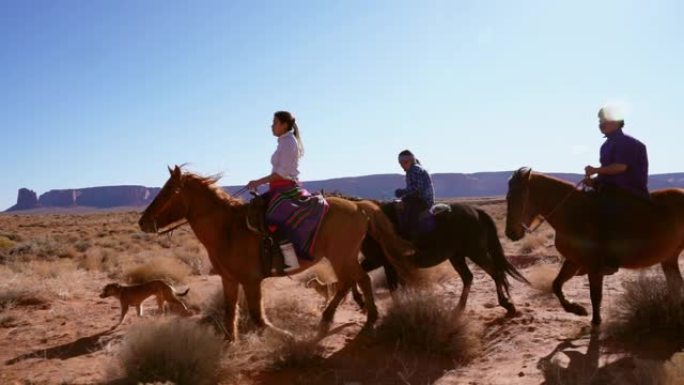 年轻的纳瓦霍兄弟姐妹骑着马，背景是纪念碑谷