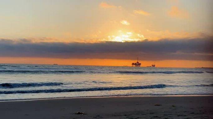 从亨廷顿海滩 (Huntington Beach) 可以欣赏到海上石油钻机平台上的壮丽日落