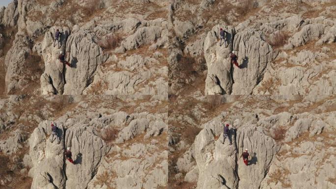 两个人用绳子爬上一块石头。运动攀登，领先。