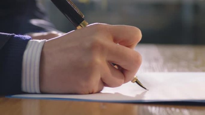 手握笔和文件签名的特写
