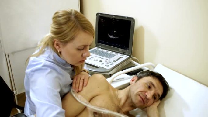 女医生使用超声波设备检查病人的心脏。高清
