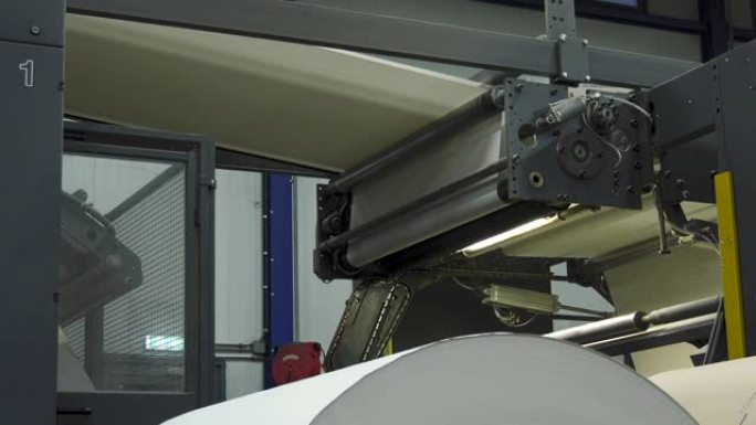 印刷厂的大纸卷和后台的繁忙机器