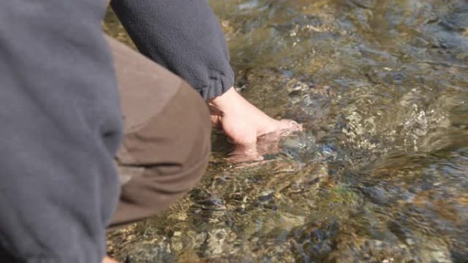 男人在河里装水瓶