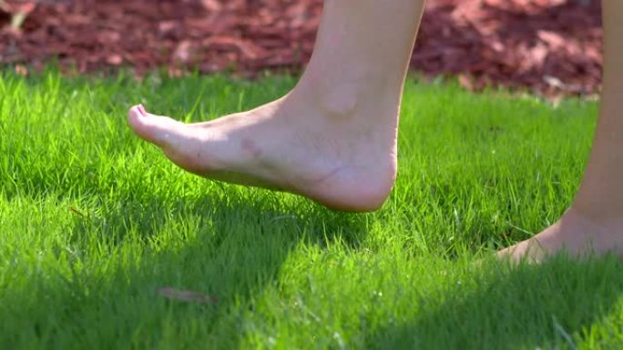 女子赤脚行走在绿色草地上4k慢动作60fps