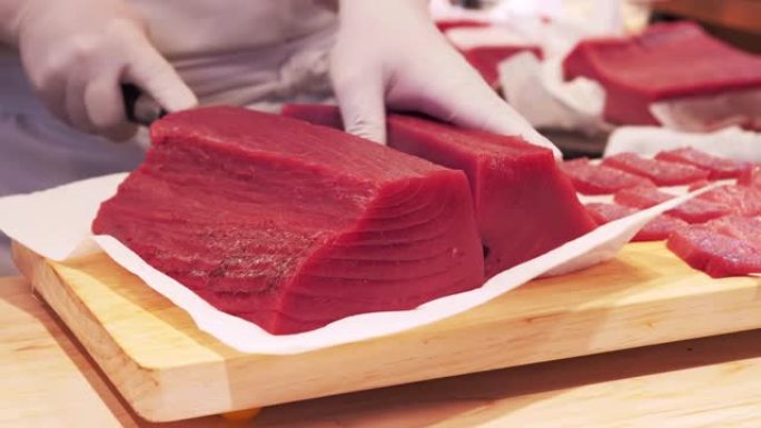 A厨师slicing tuna fillet