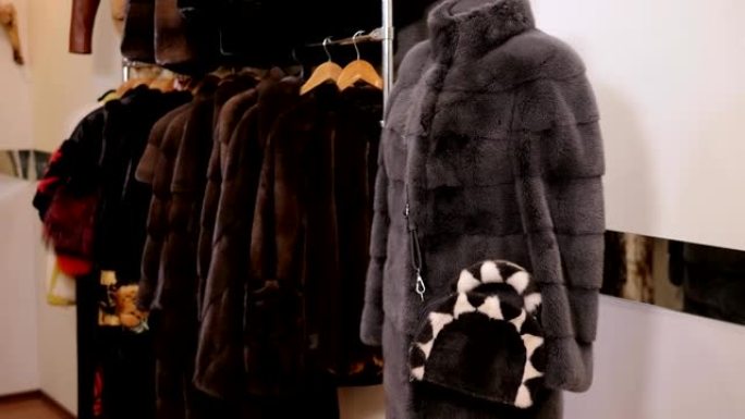 皮草商店衣架上不同颜色的漂亮皮草外套。慢速mo