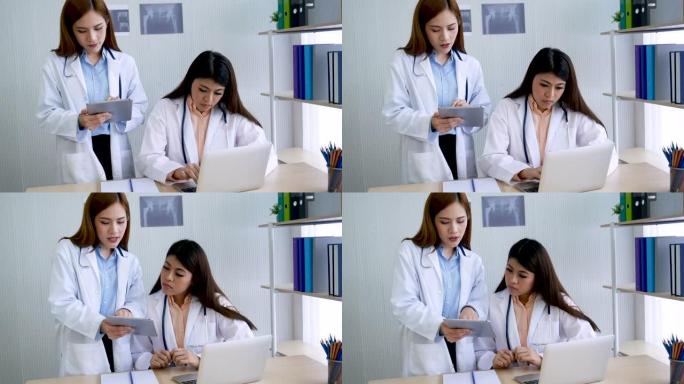 两名女医生在医院医疗保险治疗诊所咨询专业专家诊断。医生使用笔记本电脑为医疗保健肿瘤学家治疗开处方。