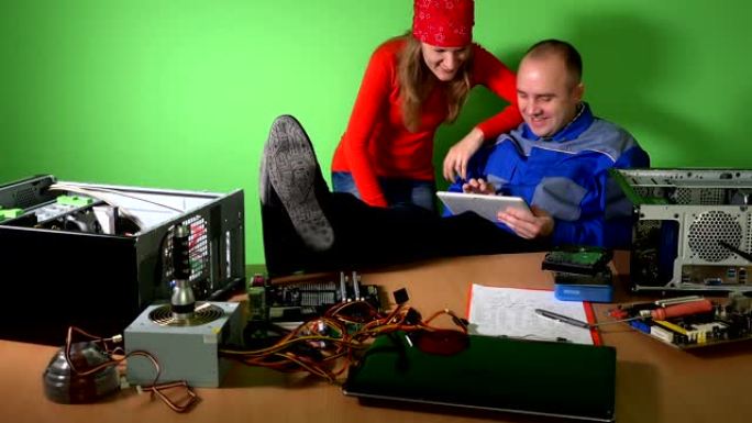粗心的技术员男女在工作中玩平板电脑