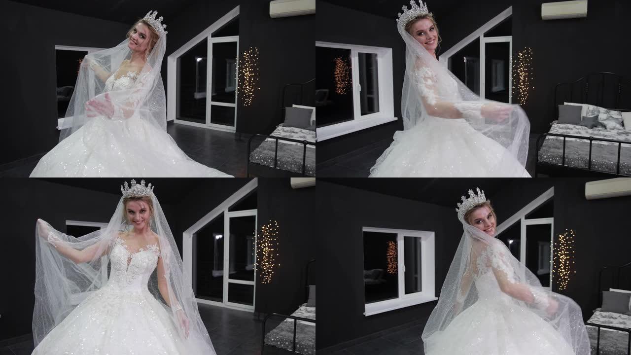 头上戴着皇冠的新娘在镜头前微笑着，双手戴着面纱。