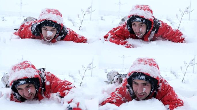 疲倦的旅行者或登山者正试图从雪山下走出来。一个在雪地里爬行的人。