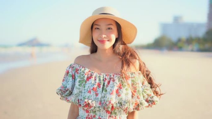 年轻的亚洲女人快乐的微笑放松环顾海滩海洋