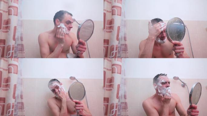 浴室里的一个男人正在脸上撒上剃须泡沫。