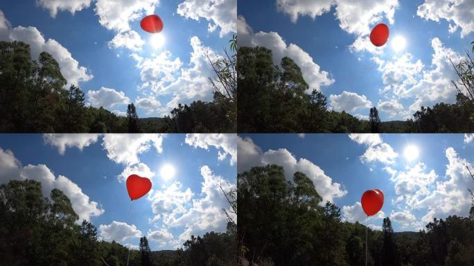 红色心形气球在蓝天上飞翔。情人节的爱情象征。爱情概念中的自由。