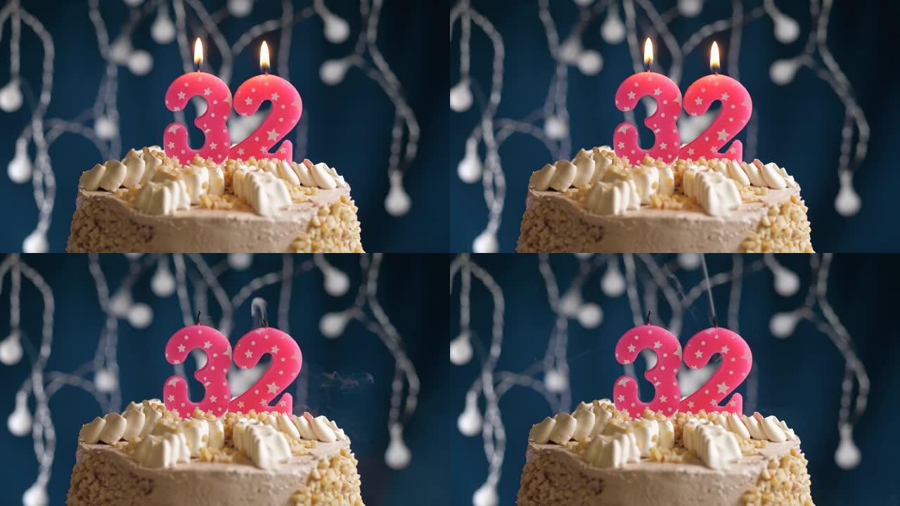 蓝色背景上有32号粉色蜡烛的生日蛋糕。蜡烛吹灭了。慢动作和特写视图