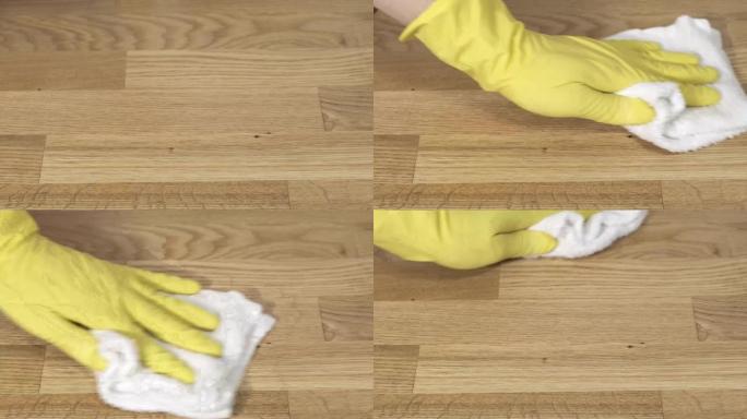 女性双手戴着黄色橡胶手套清洁公寓。洗涤镶木地板。