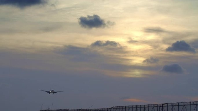 大型宽体商用飞机剪影的特写镜头在日落时降落在机场