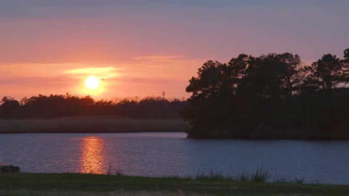 金色日落期间平静的湖，有倒影
