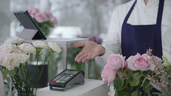非接触式支付，在花店中买家使用手机在终端上支付一束鲜花，这是一个小型企业的概念