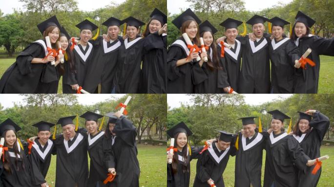 大学校园里拿着毕业证的毕业礼服快乐学生