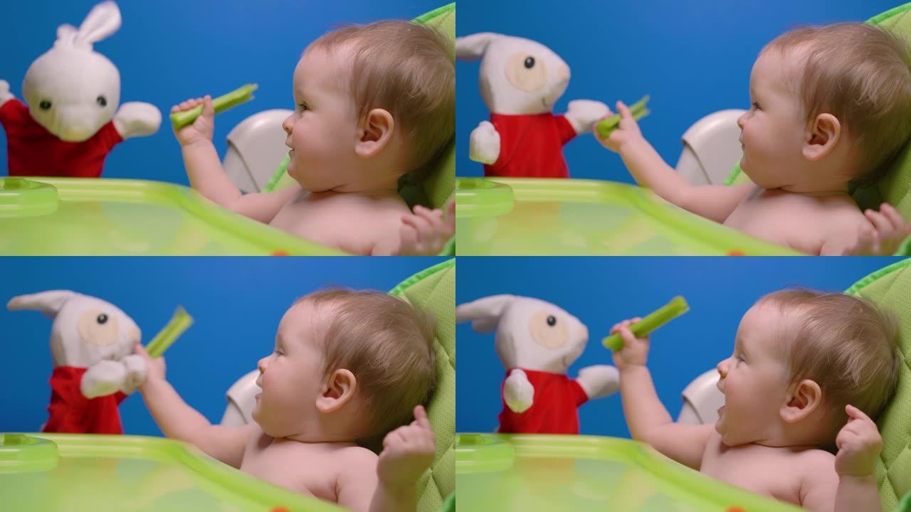 可爱的小女孩吃绿色新鲜芹菜和玩兔子娃娃