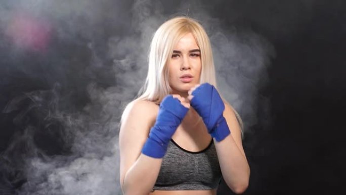漂亮的金发女子拳击手的肖像在拳击绷带摆姿势防御拳击手的姿态