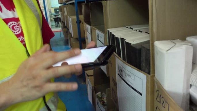 4K: 在仓库中使用智能手机检查表的工人