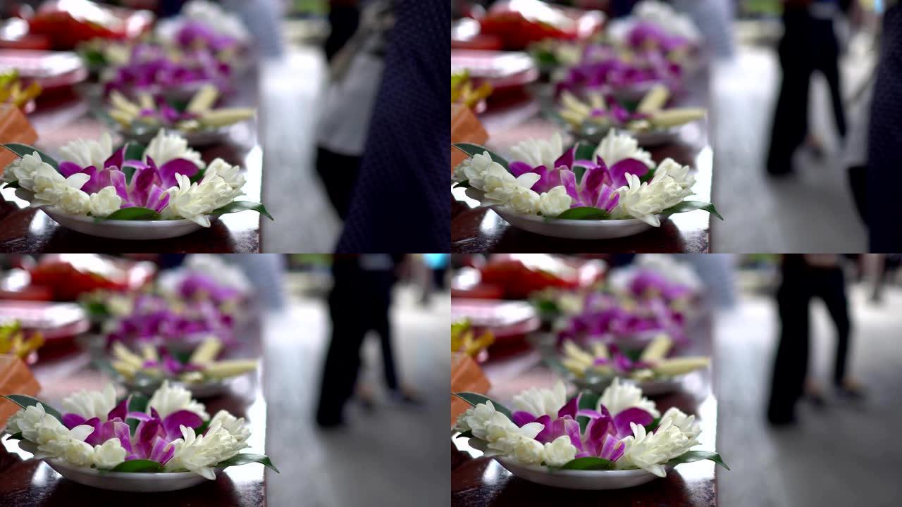 亚洲寺庙祭祀用的花。模糊的背景是崇拜者。主题在左边。