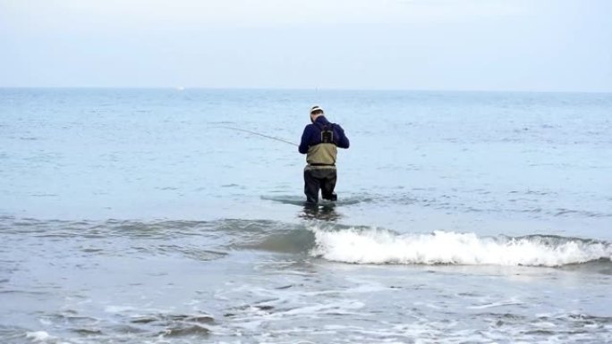渔夫用诱饵旋转钓鱼在海边钓鱼。