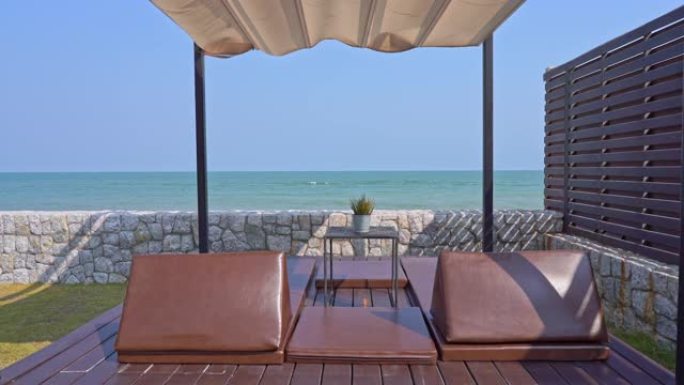 海滩海洋周围带枕头沙发躺椅的室外露台