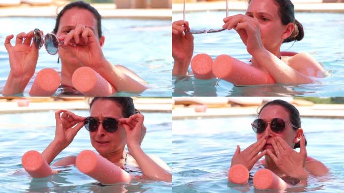 游泳池里的女人检查圆形太阳镜坦率而休闲的女士戴上太阳镜