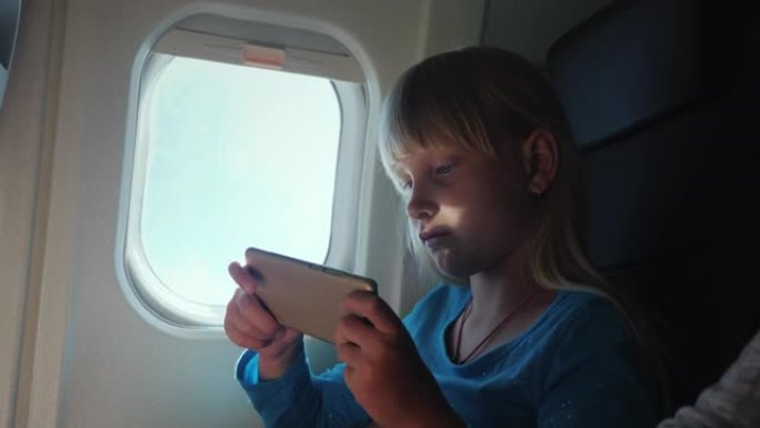 儿童在飞机上玩智能手机