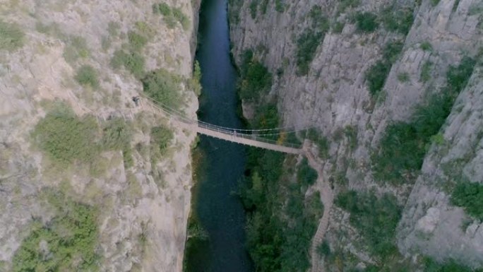 无人机向深谷和底部悬索桥的天顶下降