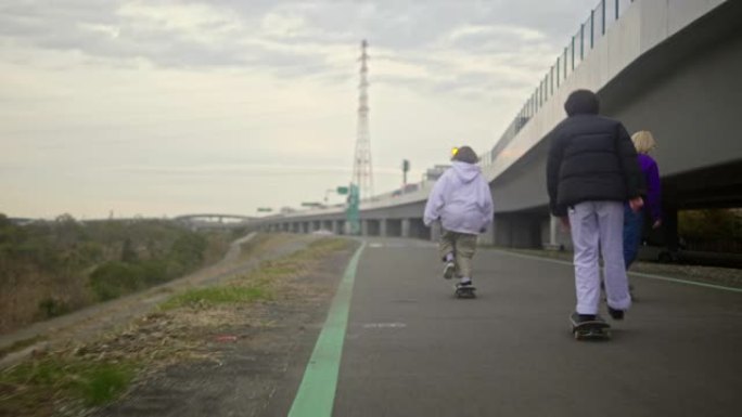 年轻女日本滑板选手骑在公路上