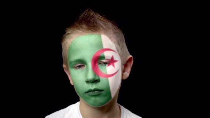 阿尔及利亚足球队的悲伤球迷。脸上涂着民族色彩的孩子。
