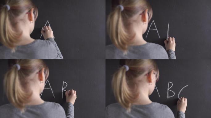 小女孩在黑板上写字母