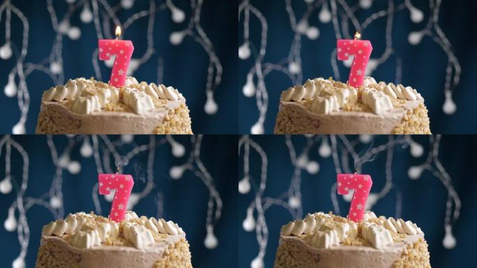 蓝色背景上有7号粉色蜡烛的生日蛋糕。蜡烛吹灭了。慢动作和特写视图