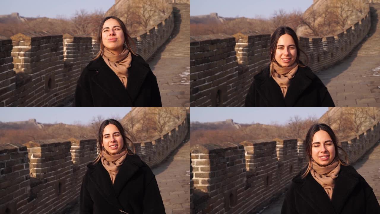 幸福的女人走在中国的长城上，冬天日落时从八达岭区的守望台下来