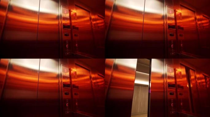 电梯的内部镜头，红灯向上移动到下一层，门正在打开
