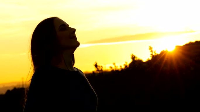 女人在日落时呼吸新鲜空气