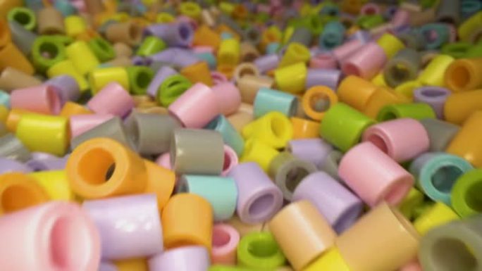 多莉拍摄的彩色短塑料管碎片堆叠在一起。塑料废物和回收