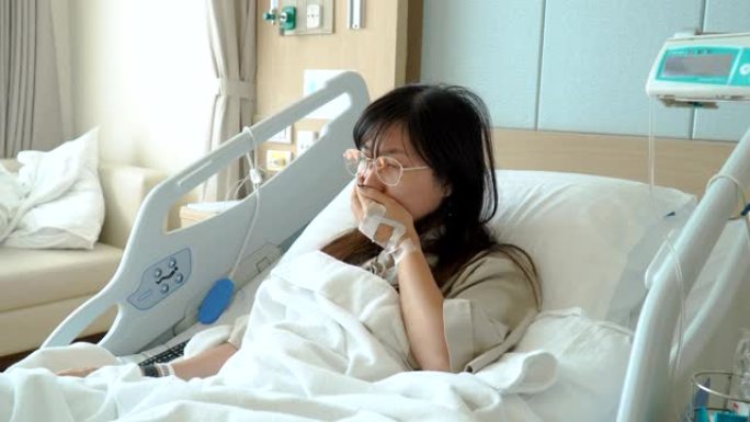 年轻女子在医院的病床上咳嗽