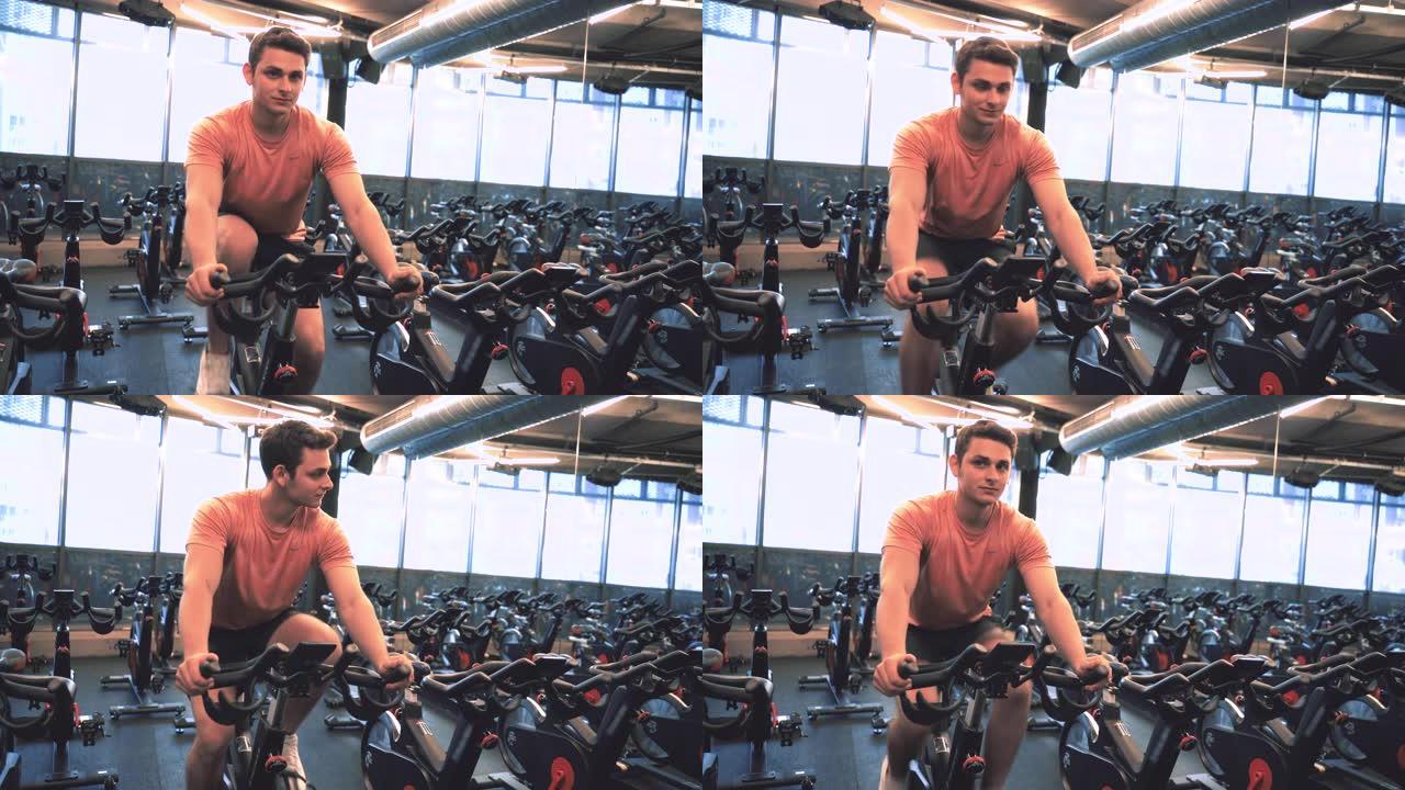 男性健身教练在固定自行车上进行体育训练
