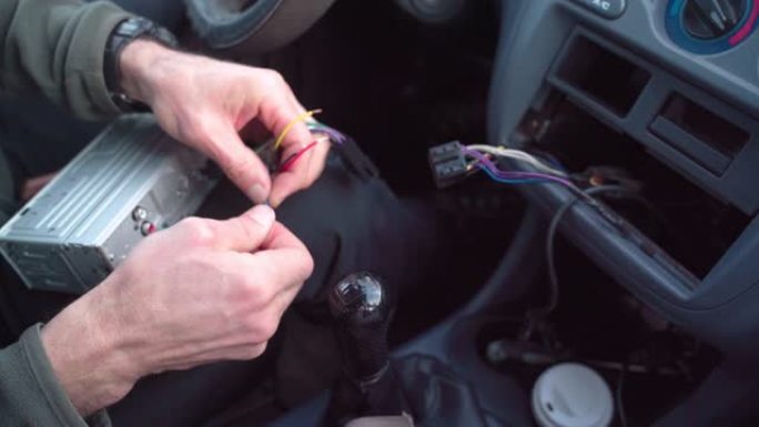 DIY. CU，专业机械师的手连接汽车音响系统的电缆。修复车载收音机的连接问题。