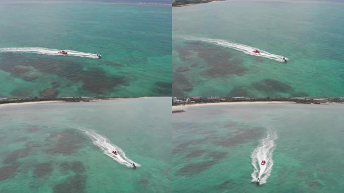 喷气式飞机拖着香蕉浮桥漂浮在日本冲绳的局部珊瑚礁上