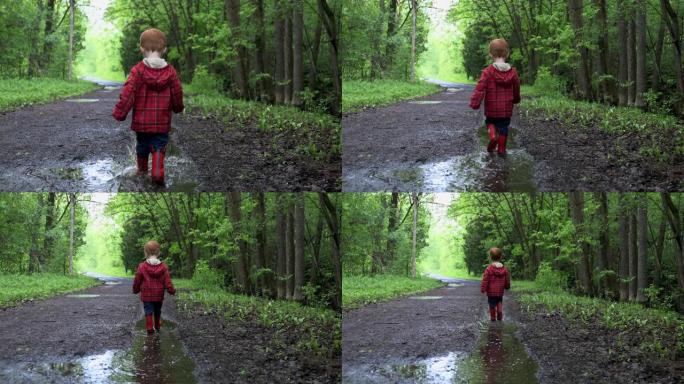 小男孩在露营地的水坑里散步