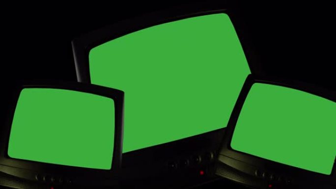 黑色背景上的三台老式电视，在绿色屏幕上切换的电视，用于图片，视频或书写的色度键屏幕。电视屏幕变色、噪