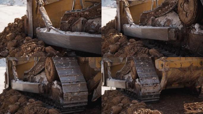 推土机在建筑工地的砾石污垢上工作的特写镜头